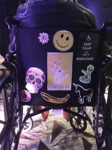 a manual wheelchair at SXSW with various stickers on the back