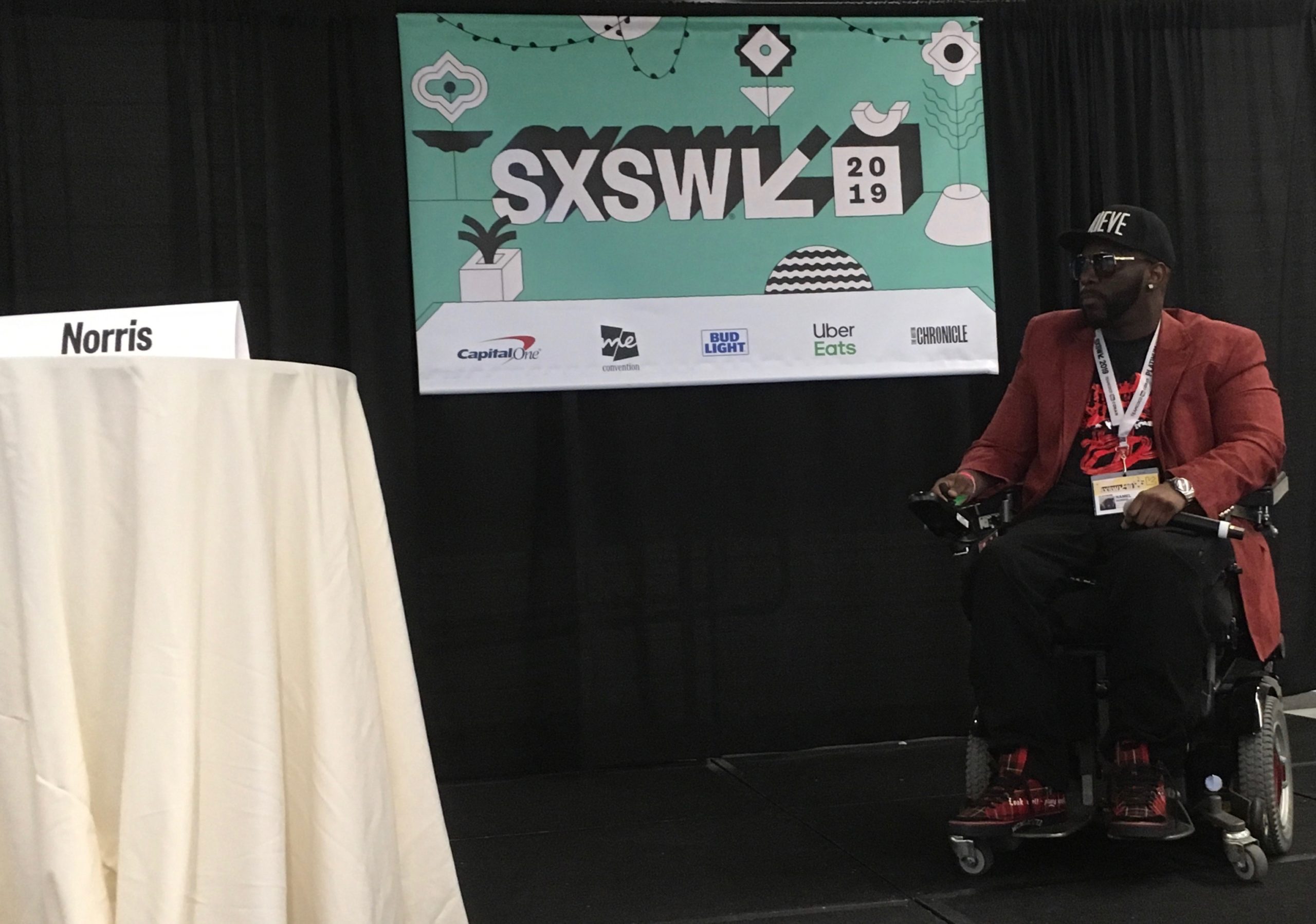 Namel Norris presenting on stage with SXSW banner on backdrop