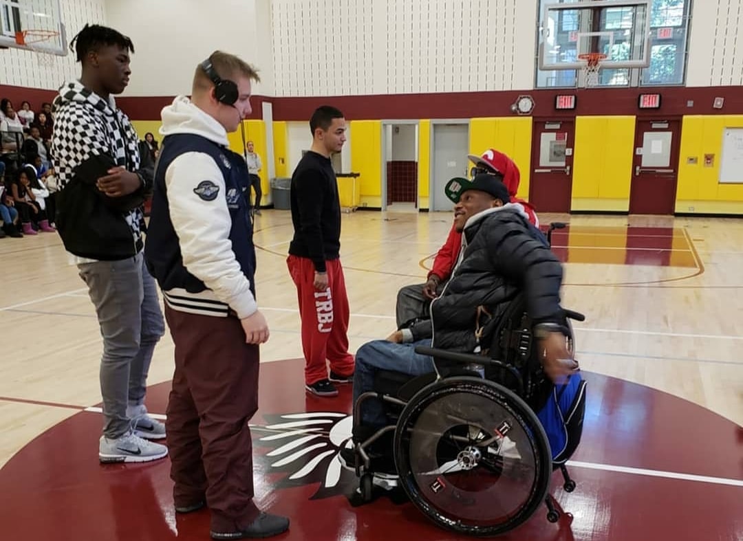 Rick & Namel talking with three male high school students in school gym