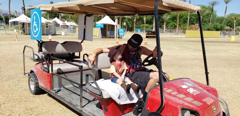 a man and a child sitting on a red golf cart with a blue universal wheelchair sign 