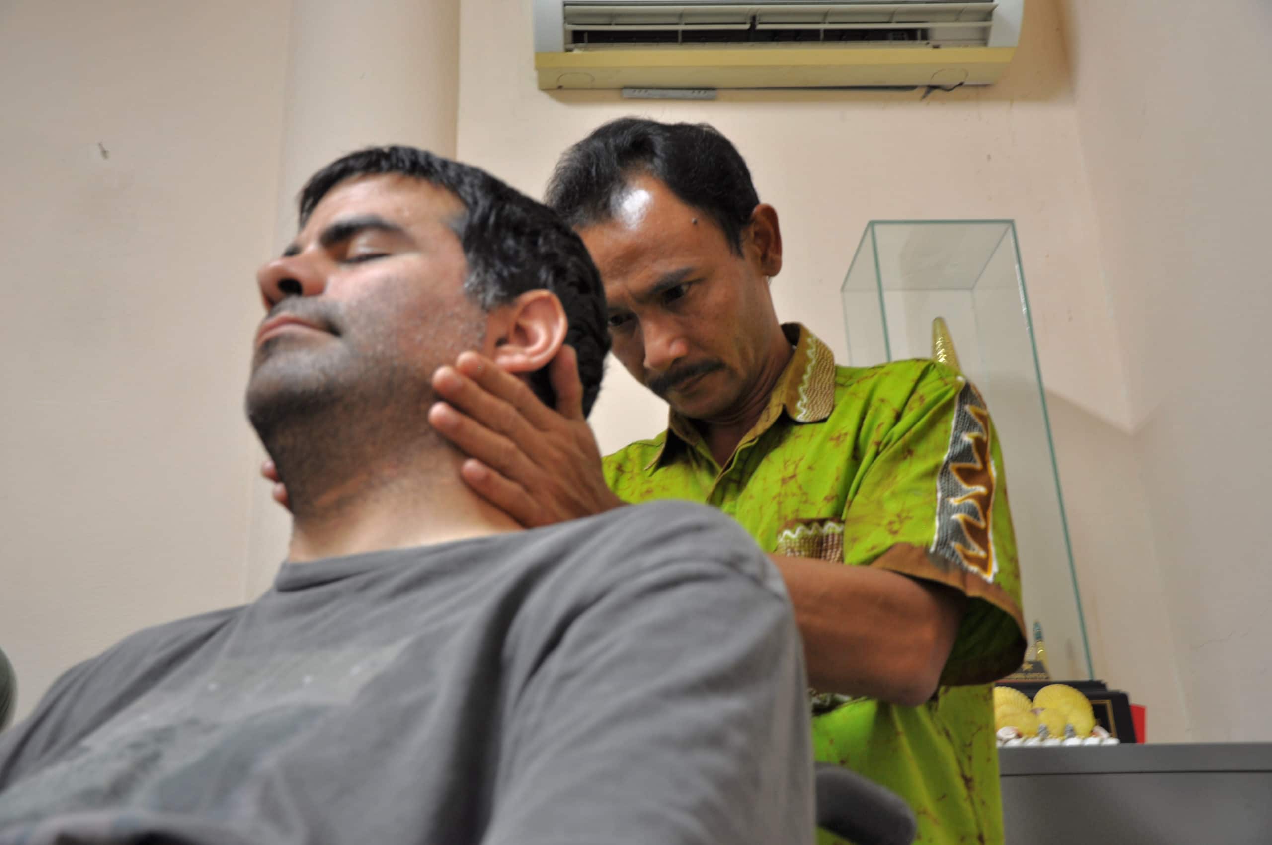 A Shaolin healer works on Minna's neck.