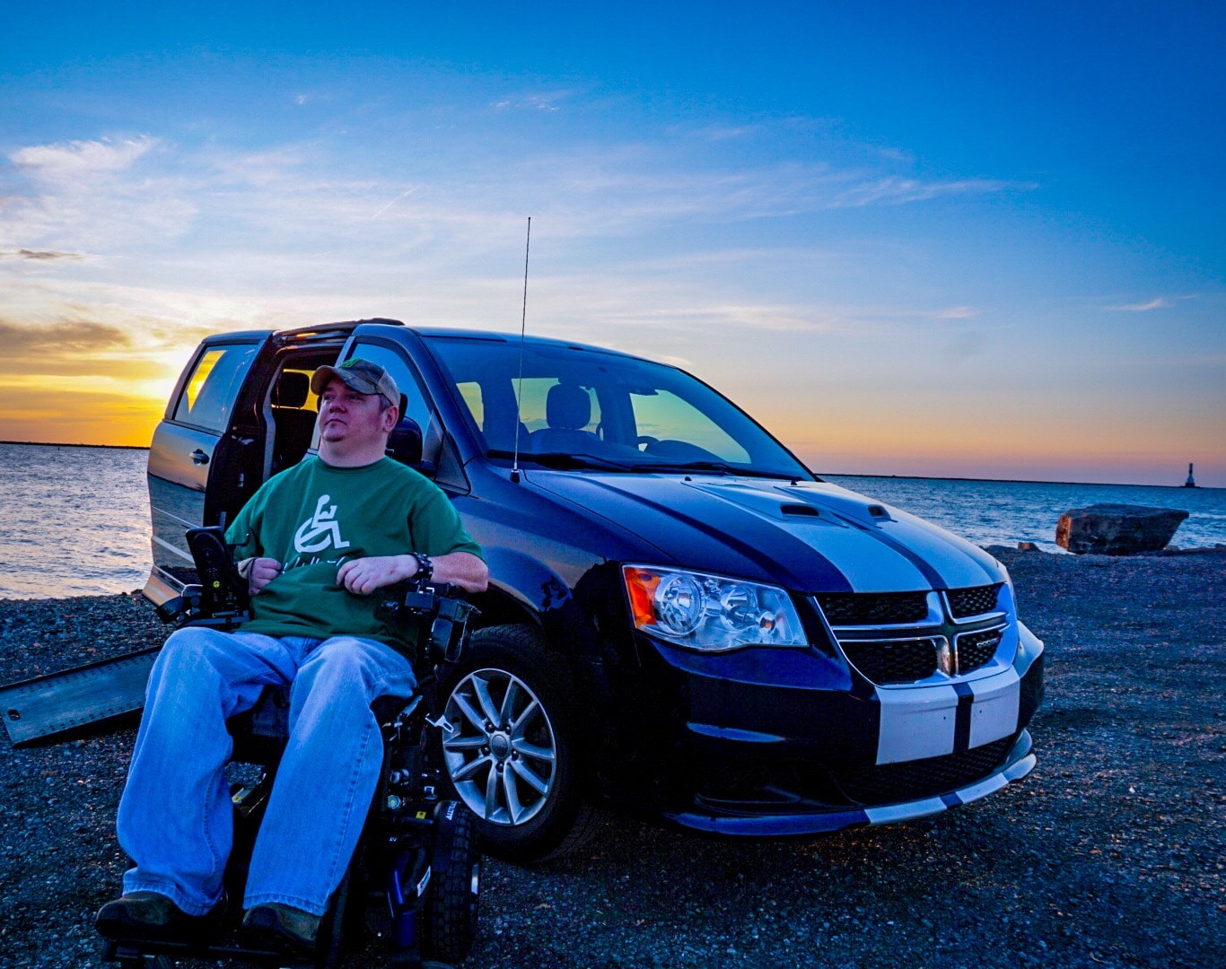 Tim Taylor sits in front of his accessible van. Lake Erie is in the background.