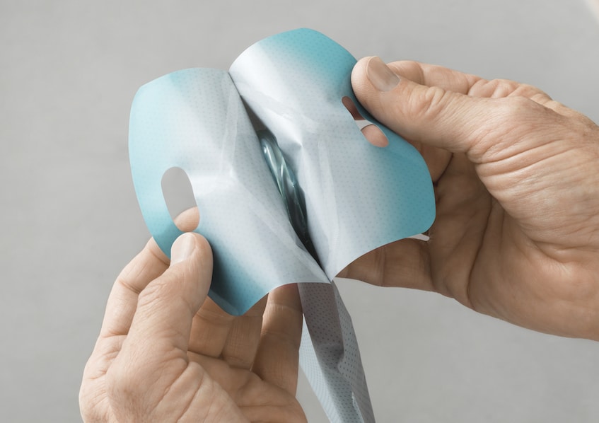 Hands opening a Speedicath® Flex Coudé Pro catheter package.