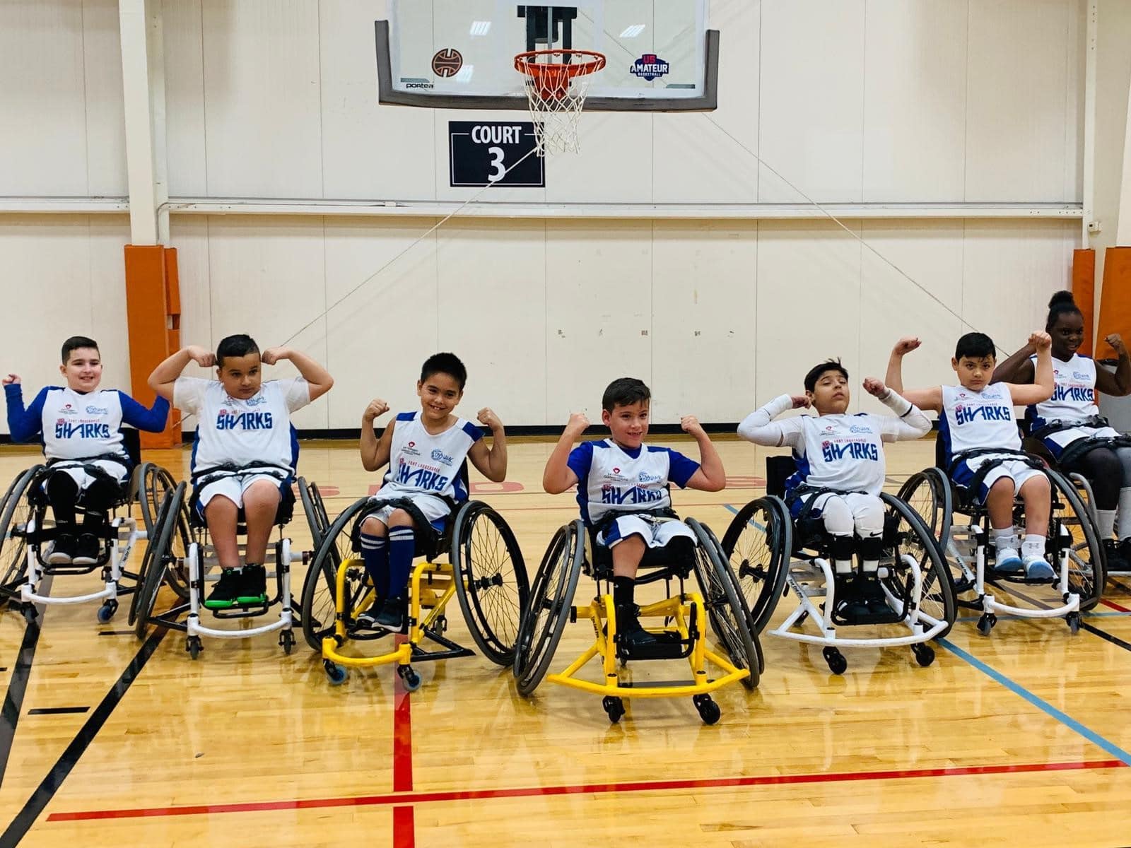 Some of the Fort Lauderdale Juniors wheelchair basketball players flexing their biceps.