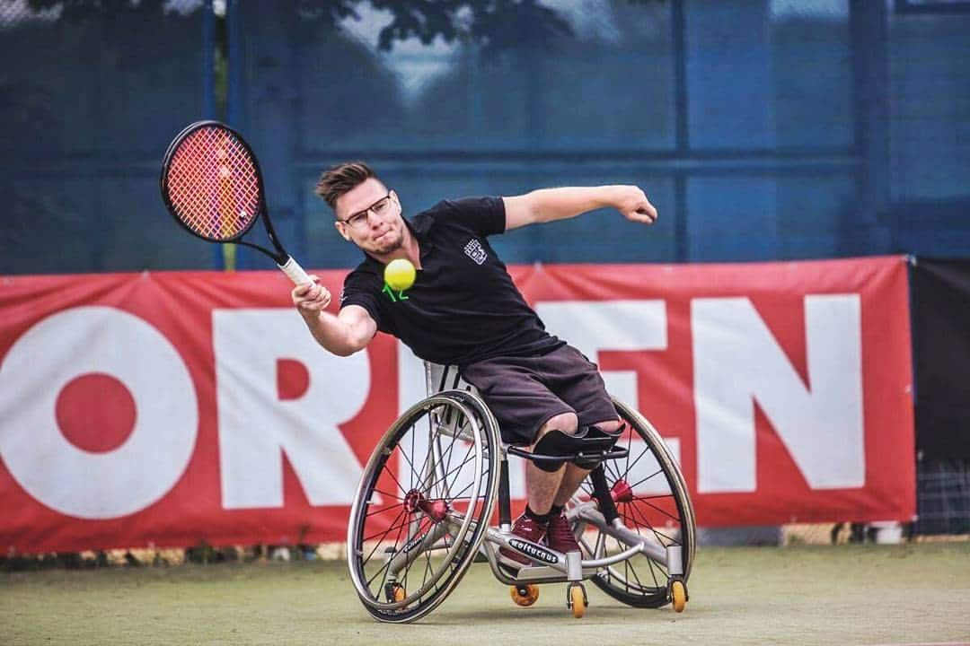 One of the McLauden brothers with his racket back ready to strike a tennis ball.