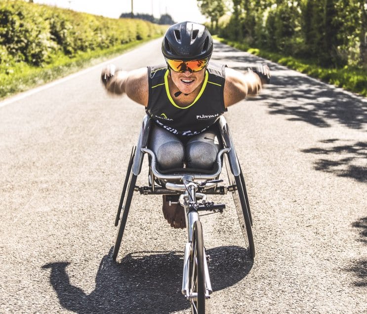 Josh Landmann racing toward the camera in a racing wheelchair.