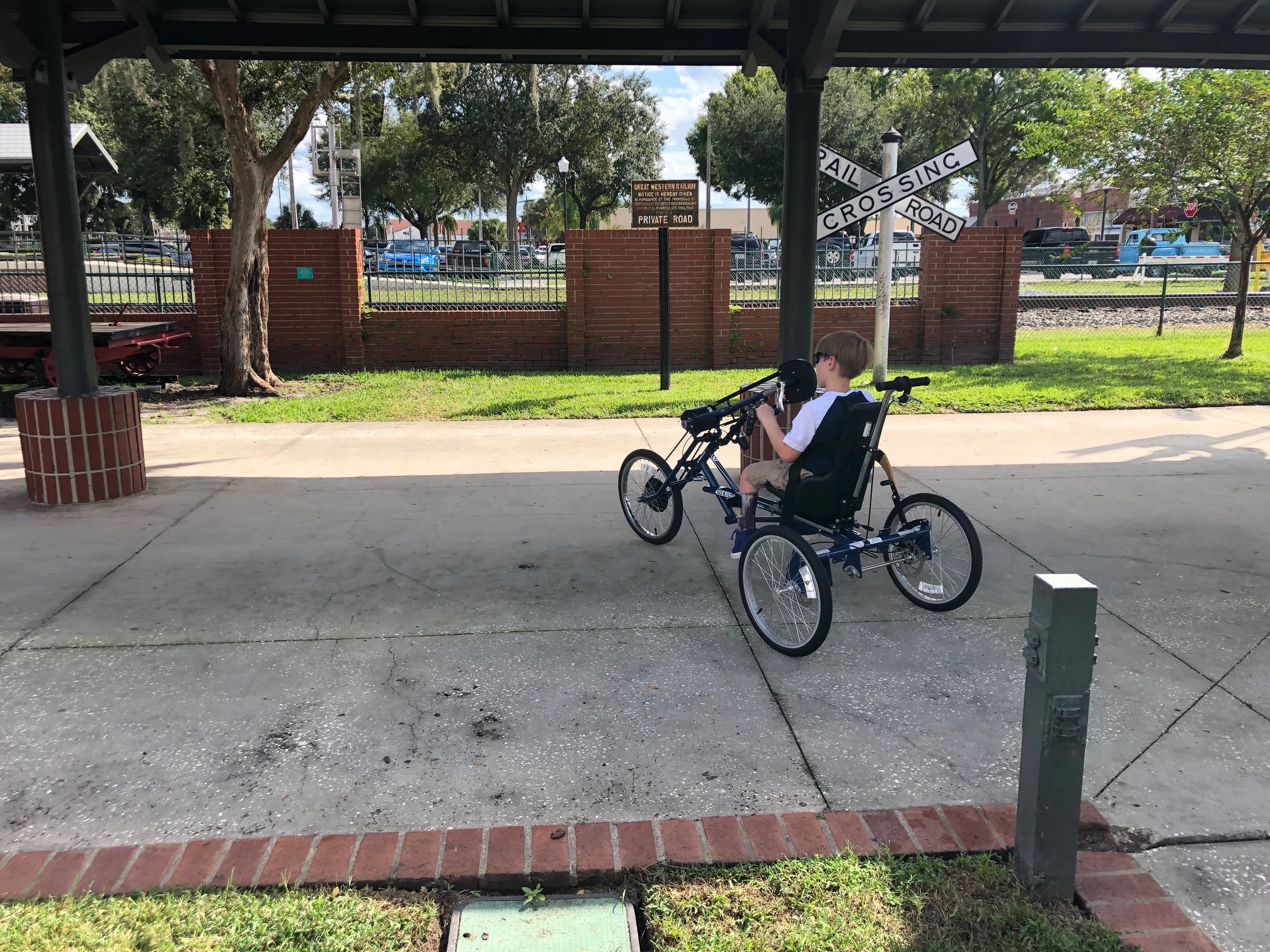 Charlie riding his handcycle from behind heading away from the camera.