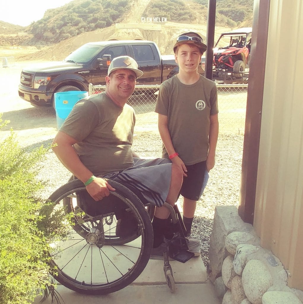 Anthony Orefice in his wheelchair with his son standing next to him.