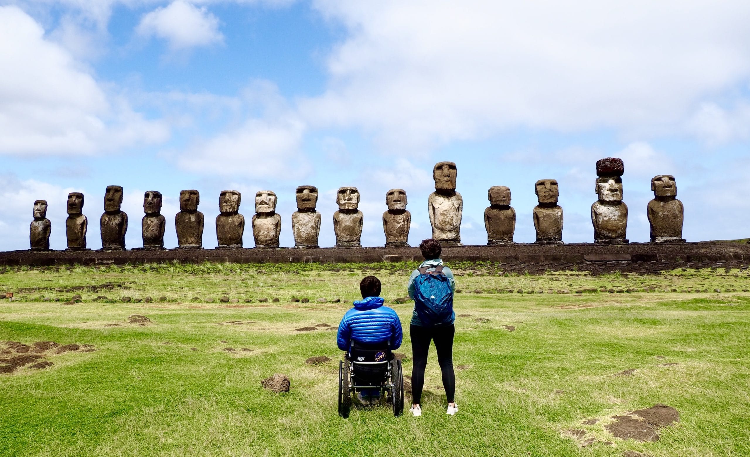 Pierre in his wheelchair and Myriam standing with their backs to the camera. They are looking at the statues of Easter Island.