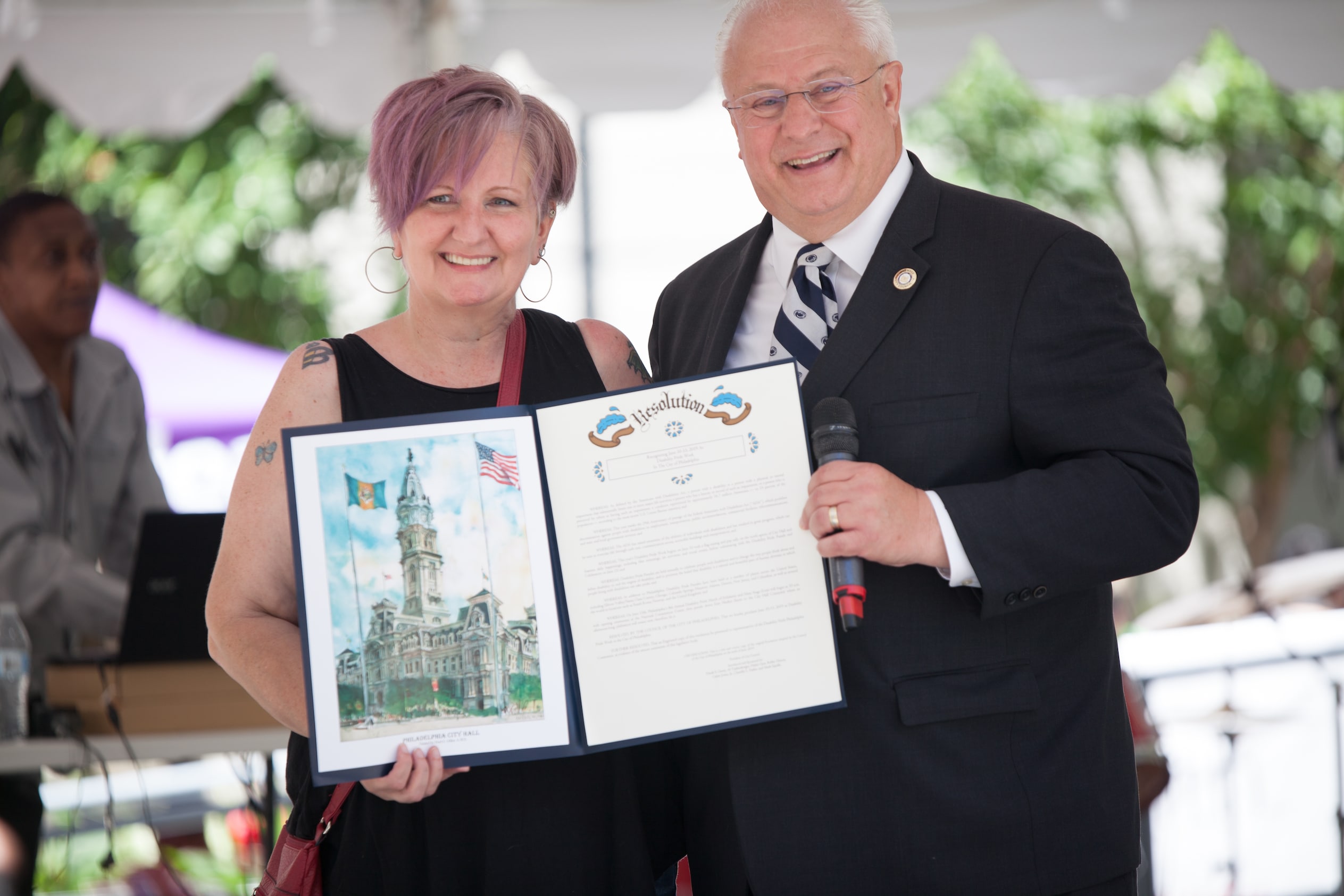 Vicki Landers and a man hold up resolution document.