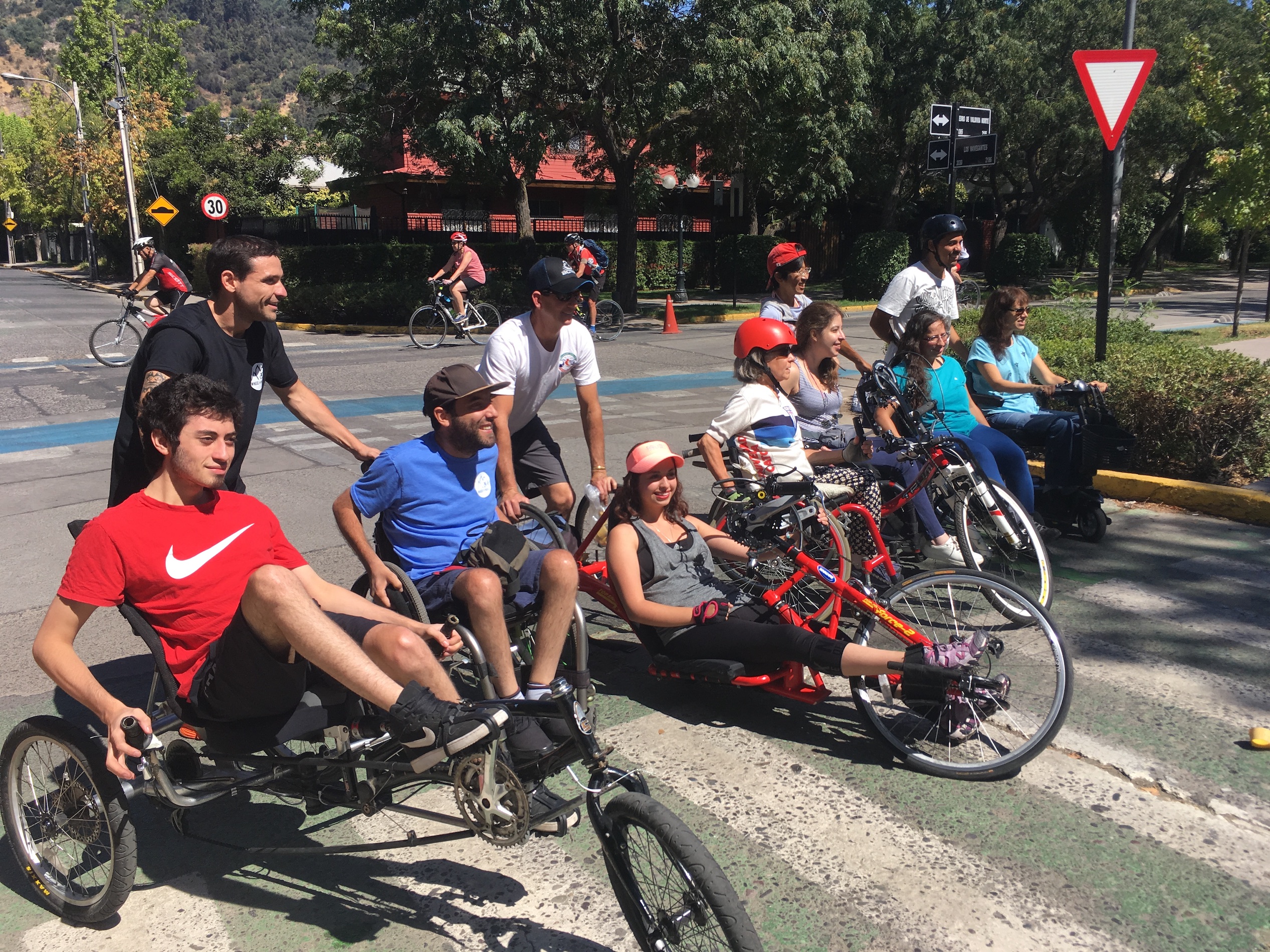 A group of people on adaptive bikes on a street.