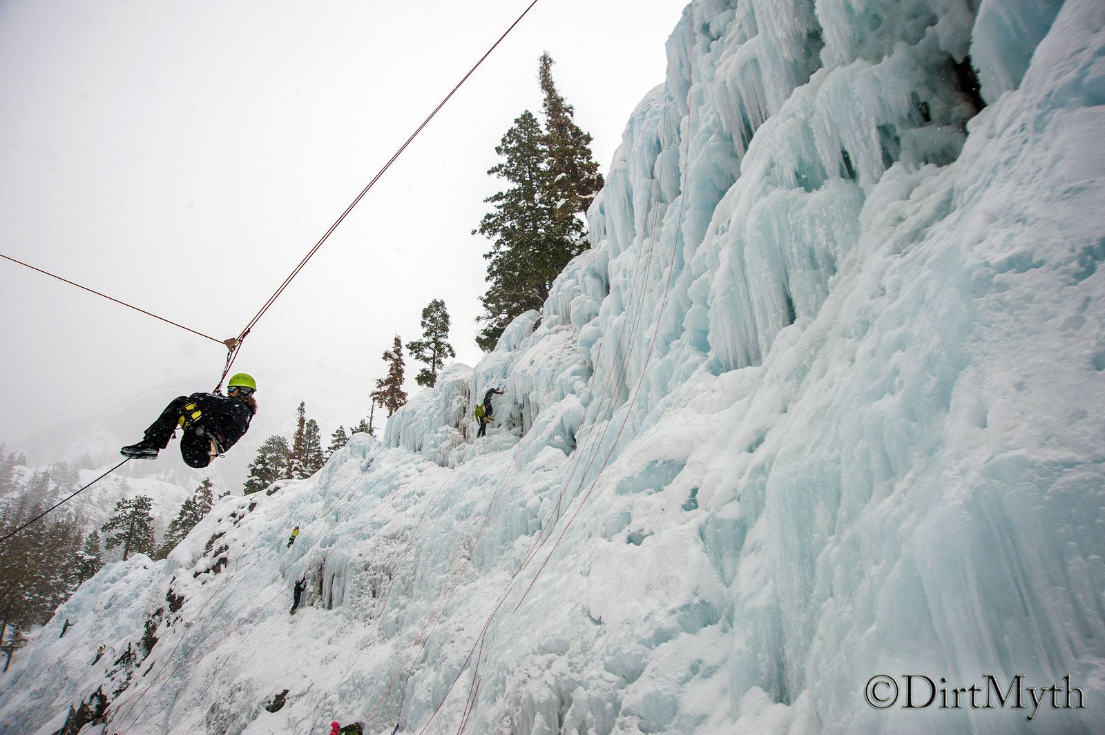 A person zips down an icy mountain with the help of a rope and pulley system. 